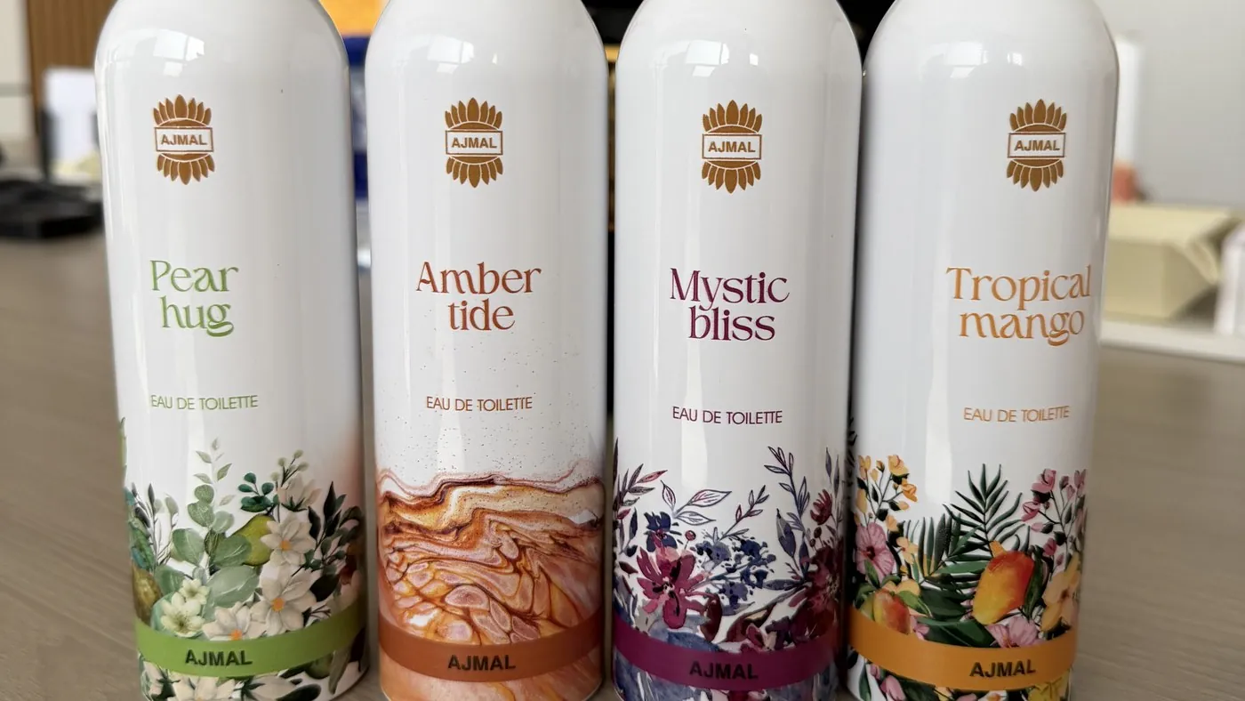 Four Ajmal body-spray cans, each printed with a different floral design