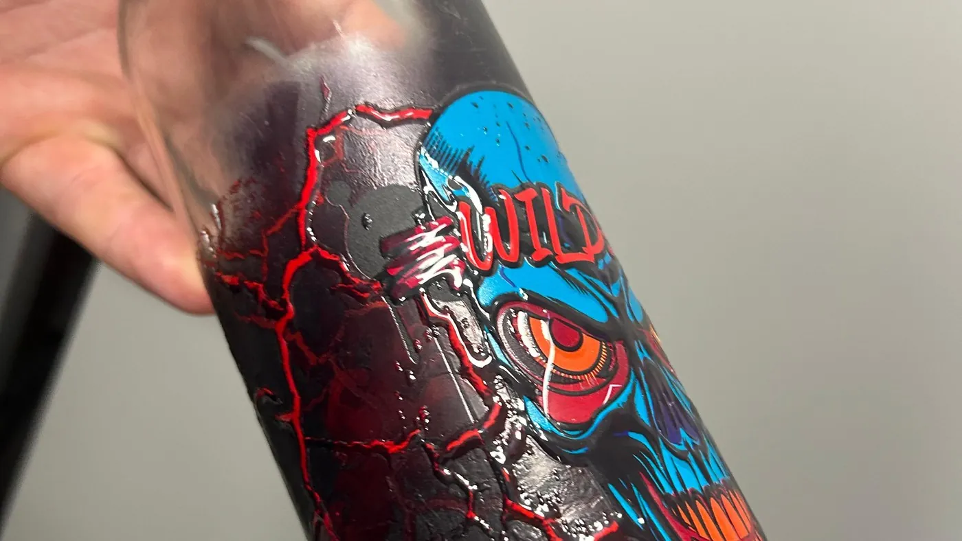 Close-up of a printed bottle with raised, textured artwork